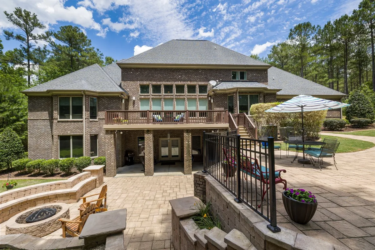 A luxury brick house with a large terrace, fire pit, and a well-kept garden, reflecting strong brand identity.